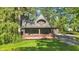 Stunning home featuring a brick porch, balcony, dormer window, and mature trees at 710 N Spring St, Greenfield, IN 46140