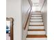 Bright stairway featuring fresh, white risers, a wooden handrail and a glimpse into an adjacent living space at 710 N Spring St, Greenfield, IN 46140