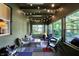 Inviting sunroom with an orange fireplace, charming string lights and several seating areas to enjoy the outdoors at 710 N Spring St, Greenfield, IN 46140