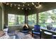 Inviting sunroom with an orange fireplace, charming string lights and several seating areas to enjoy the outdoors at 710 N Spring St, Greenfield, IN 46140