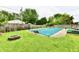 Fenced-in backyard featuring a covered in-ground pool, fire pit, and lawn at 73 Suncrest Dr, Greenwood, IN 46143