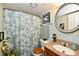 Bathroom featuring a round mirror, leafy shower curtain, and wood-style sink at 73 Suncrest Dr, Greenwood, IN 46143