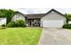 Well-maintained gray home featuring an attached garage, driveway and lush front yard at 73 Suncrest Dr, Greenwood, IN 46143