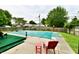 Covered in-ground pool in backyard with patio, red outdoor chairs, and privacy fence at 73 Suncrest Dr, Greenwood, IN 46143