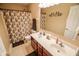 Bathroom with double vanity, floral shower curtain, and decorative wall art at 7322 Stones River Dr, Indianapolis, IN 46259