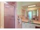 Retro bathroom with pink tile, walk-in shower, and vanity with integrated sink at 7401 Spring Mill Rd, Indianapolis, IN 46260