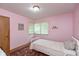 Pink bedroom with a corner window, hardwood floors, and single bed at 7401 Spring Mill Rd, Indianapolis, IN 46260