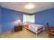 Bedroom with blue walls features a window and full-sized bed on tan carpeting at 7401 Spring Mill Rd, Indianapolis, IN 46260