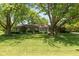 Charming single-story home with stone exterior and mature trees in a well-maintained front yard at 7401 Spring Mill Rd, Indianapolis, IN 46260