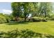 Spacious front yard with mature trees and green grass at 7401 Spring Mill Rd, Indianapolis, IN 46260