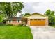 Charming brick home with a green lawn, mature trees, and a two-car garage with wood doors at 7580 Sherry Ln, Brownsburg, IN 46112