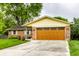 View of a brick house and light brown garage door with green lawn and driveway at 7580 Sherry Ln, Brownsburg, IN 46112