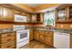 A kitchen featuring wooden cabinets, granite countertops, and white appliances at 7580 Sherry Ln, Brownsburg, IN 46112