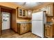 Open kitchen has wood cabinets, white appliances and access to exterior at 7580 Sherry Ln, Brownsburg, IN 46112