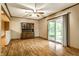 Living room with hardwood floors, fan, and glass sliding door to deck at 7580 Sherry Ln, Brownsburg, IN 46112