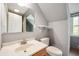 Bathroom with vanity, toilet, wood floors, and natural light from the window at 7910 N College Ave, Indianapolis, IN 46240