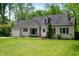Charming home featuring a manicured lawn and stone detailing around the front picture window at 7910 N College Ave, Indianapolis, IN 46240
