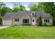 Charming home featuring a manicured lawn and stone detailing around the front picture window at 7910 N College Ave, Indianapolis, IN 46240