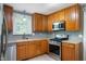 Kitchen featuring stainless steel appliances, wooden cabinets, and a gas range at 7910 N College Ave, Indianapolis, IN 46240