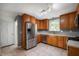 Well-lit kitchen featuring stainless steel appliances, wooden cabinets, and tile floors at 7910 N College Ave, Indianapolis, IN 46240