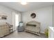 Cozy Bedroom featuring a crib, changing table, and comfortable glider at 8958 Wooster Ct, Fishers, IN 46038