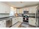 Well-equipped kitchen with white cabinets, stainless steel appliances, and tile backsplash at 8958 Wooster Ct, Fishers, IN 46038