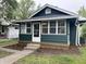 Charming home with a dark green exterior and a sunny, glass enclosed, front porch at 946 N Somerset Ave, Indianapolis, IN 46222