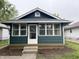 Charming home with a dark green exterior and a sunny, glass enclosed, front porch at 946 N Somerset Ave, Indianapolis, IN 46222