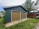This two-car garage is painted green with two brown garage doors at 946 N Somerset Ave, Indianapolis, IN 46222