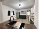Updated kitchen featuring dark green cabinets, butcher block countertops, and stainless steel appliances at 946 N Somerset Ave, Indianapolis, IN 46222
