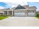 Lovely exterior features a three car garage, stone accents, brick, and well-maintained landscaping at 963 Booneway Ln, Bargersville, IN 46106