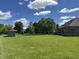 Lush green backyard showing a storage shed and stone patio, all surrounded by mature trees and landscaping at 10 Sara Ct, Whiteland, IN 46184