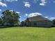 Beautiful backyard with a spacious lawn, mature trees, and a stone patio with a built-in grilling area at 10 Sara Ct, Whiteland, IN 46184