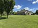 Sprawling green backyard with mature trees leads to a well-kept home with a shed and patio at 10 Sara Ct, Whiteland, IN 46184