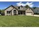 Attractive brick home with arched window, manicured lawn, and a front porch with rocking chairs at 10 Sara Ct, Whiteland, IN 46184