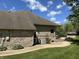 Exterior showcasing a manicured lawn, a stone patio, and the home's siding and brick accents at 10 Sara Ct, Whiteland, IN 46184