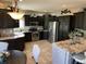 Spacious kitchen features stainless steel appliances, dark wood cabinets, granite countertops, and breakfast bar at 10 Sara Ct, Whiteland, IN 46184