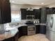 Well-equipped kitchen featuring stainless steel appliances, granite countertops, and dark wood cabinets at 10 Sara Ct, Whiteland, IN 46184