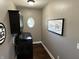Laundry room with black washer and dryer, overhead cabinet, a small round window, and modern decor at 10 Sara Ct, Whiteland, IN 46184