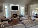 Comfortable living room featuring a brick fireplace, large TV, and plenty of seating with natural lighting at 10 Sara Ct, Whiteland, IN 46184