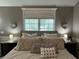 Main bedroom showcasing a large window, decorative sconces, and a comfortable bed with plush pillows at 10 Sara Ct, Whiteland, IN 46184