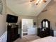 Main bedroom with vaulted ceilings, dark wood furniture, and an adjacent door leading to the closet at 10 Sara Ct, Whiteland, IN 46184