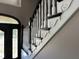 View of an elegant staircase with white railings and black accents near the front door at 10 Sara Ct, Whiteland, IN 46184