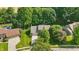 Aerial of brick home with a two-car garage and a well-maintained lawn surrounded by mature trees at 10418 Forest Creek Dr, Indianapolis, IN 46239
