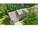 Aerial view of a brick home with a well-manicured lawn and lush landscaping at 10418 Forest Creek Dr, Indianapolis, IN 46239