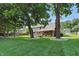 Expansive backyard with a deck, lush green lawn, mature trees, and detailed landscaping at 10418 Forest Creek Dr, Indianapolis, IN 46239
