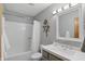 Bright bathroom featuring a tub with shower, light walls, a mirror, and a single sink vanity at 10418 Forest Creek Dr, Indianapolis, IN 46239