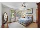 Bright bedroom featuring a ceiling fan, light neutral walls, and large windows with views of the exterior at 10418 Forest Creek Dr, Indianapolis, IN 46239