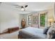 Well-lit bedroom featuring light neutral walls, carpet, a ceiling fan, and large windows with exterior views at 10418 Forest Creek Dr, Indianapolis, IN 46239