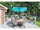 Outdoor deck features a table with an umbrella, surrounded by a well-maintained lawn and lush greenery at 10418 Forest Creek Dr, Indianapolis, IN 46239